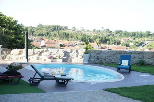 a swimming pool in a yard with a table and chairs at Le refuge in Tondela