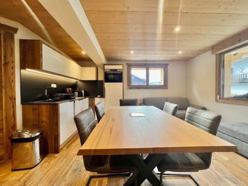 une salle à manger et une cuisine avec une table et des chaises dans l'établissement Appartement moderne au cœur de Notre-Dame-de-Bellecombe, proche pistes et commodités - FR-1-505-185, à Notre-Dame-de-Bellecombe