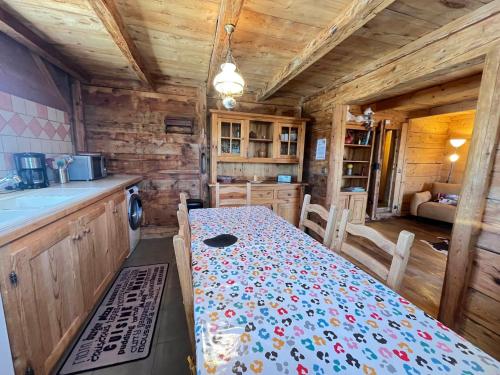 - une cuisine avec une table dans une cabane en bois dans l'établissement Mazot savoyard avec 2 chambres, WIFI, animaux admis, parking privatif - FR-1-505-217, à Notre-Dame-de-Bellecombe