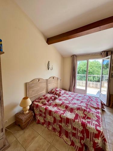 une chambre avec un lit et une grande fenêtre dans l'établissement Villa provençale au coeur du golfe, à Grimaud