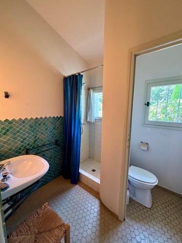 une salle de bain avec un lavabo, des toilettes et une douche dans l'établissement Villa provençale au coeur du golfe, à Grimaud