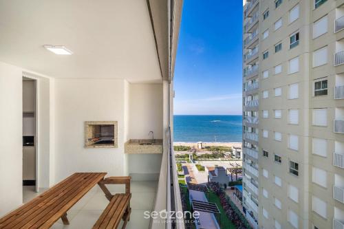 a balcony of a building with a view of the ocean at Condomínio a beira-mar c/ piscina - SHC in Piçarras