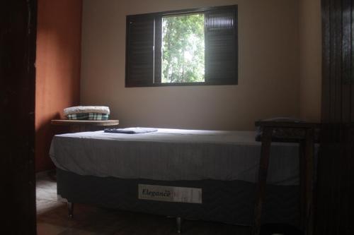 a bed in a room with a window at Refúgio Leve Amor in Águas de Lindóia
