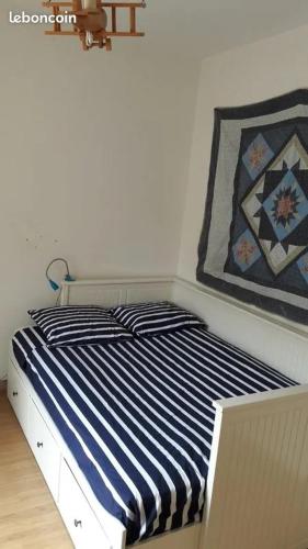 un lit avec des draps rayés bleus et blancs et une couette dans l'établissement Villa climatisée avec piscine, à Opio