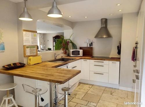 une cuisine avec des armoires blanches et un comptoir en bois dans l'établissement Villa climatisée avec piscine, à Opio