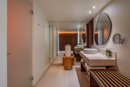 a bathroom with two sinks and a mirror at Kimpton Atlantico Algarve by IHG in Albufeira