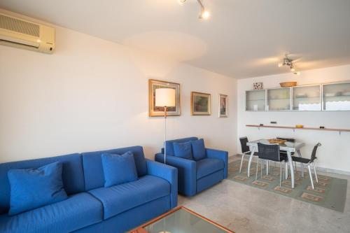 un salon avec un canapé bleu et une table dans l'établissement Montecarlo vista - Sea view, à Beausoleil
