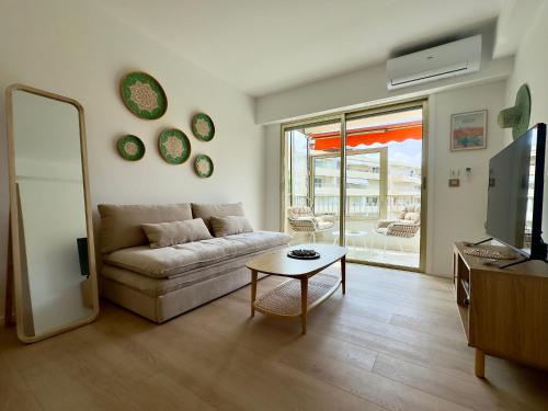 un salon avec un canapé et une table dans l'établissement Le Cirodde By SCLS Locations, à Cannes