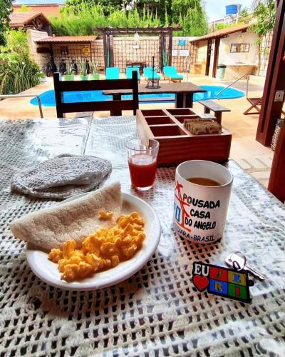 a table with a plate of food and a cup of coffee at Pousada Casa Do Angelo in Jericoacoara