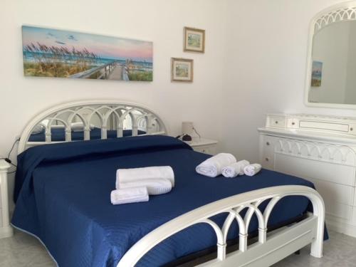 a bedroom with a blue bed with towels on it at BenitiKe House in Cala Gonone