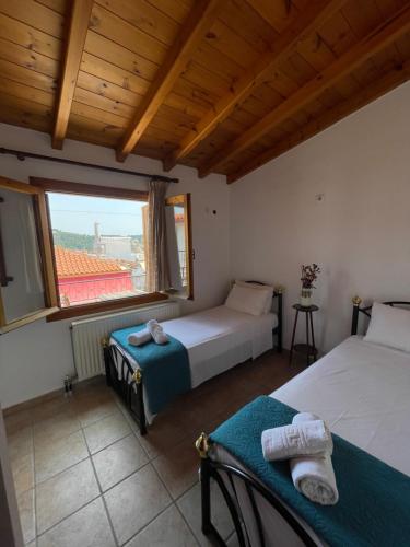 a bedroom with two beds and a large window at Lula's House in Skiathos Town