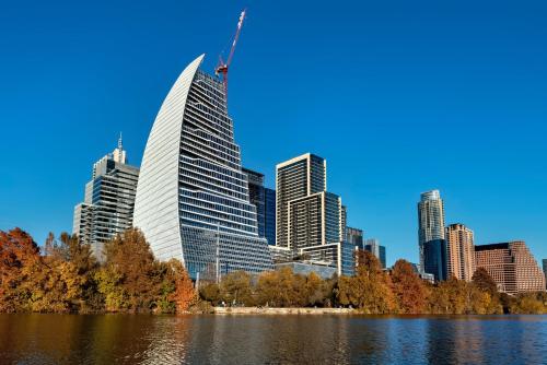 a tall building with a crane on it in front of a city at Holiday Inn Austin -Town Lake by IHG in Austin