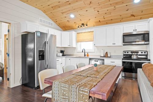a kitchen with a wooden table and a refrigerator at The Lodges at Eden Reserve - Back Cabins - Near Ark in Williamstown