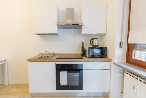 a small kitchen with a sink and a microwave at Casa Afrodite Bilocale con Sauna e Vasca Privata in Perosa Argentina