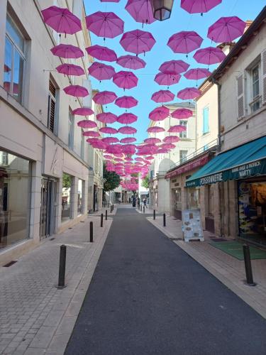 une rangée de parasols roses suspendus au-dessus d'une rue dans l'établissement Périgueux, au cœur de l'histoire, à Périgueux