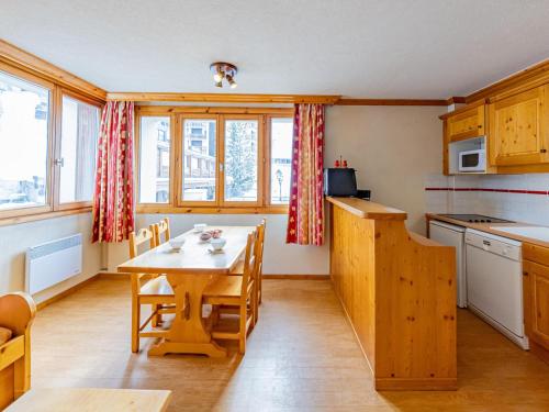 une cuisine avec une table et des chaises dans une pièce dans l'établissement T1 26m², 4 pers, au pied des pistes et commerces - FR-1-807-27, à Saint-François-Longchamp