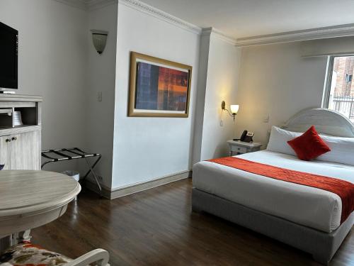 a hotel room with a bed and a table at Hotel Vintage in Bogotá