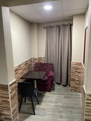 a room with a chair and a table in a room at Hotel Guest House Inn in San Pedro Sula