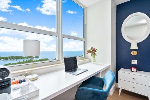 a desk with a laptop and a chair in front of a window at MVR Suite The Secret to Luxury Living Is Right Here in Miami