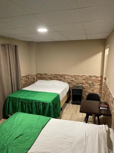 a room with two beds and a chair and a fireplace at Hotel Guest House Inn in San Pedro Sula