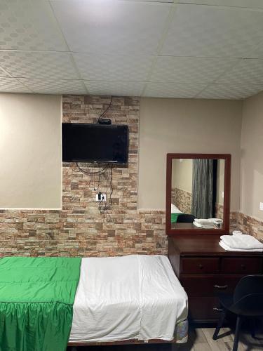 a bedroom with a bed and a mirror at Hotel Guest House Inn in San Pedro Sula