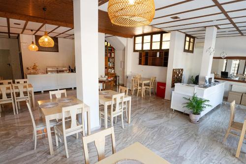 a restaurant with tables and chairs and a counter at The White Rose Hotel in Poros