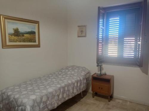 a bedroom with a bed and a picture on the wall at i giardini di Ailobran in Narbolia