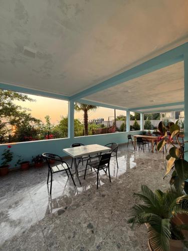 un patio con tavolo, sedie e finestre di Temo's guest house in Kvariati a Kvariati