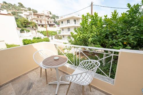 a balcony with two chairs and a table at The White Rose Hotel in Poros