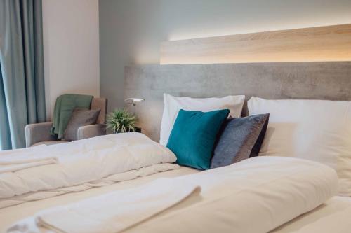 a bedroom with two white beds with blue pillows at Pascals Ruhestube in Mörsdorf