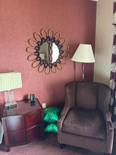 un salon avec une chaise et un miroir dans l'établissement Happy B, à La Côte-Saint-André