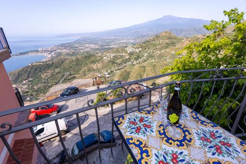 a table on a balcony with a bottle of wine at mimma's home in Castelmola