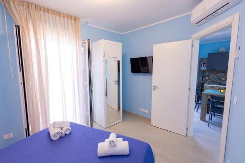 a blue room with a blue table with two towels at mimma's home in Castelmola