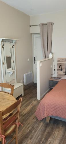 une chambre avec un lit, une table et un miroir dans l'établissement Au coeur de Marie, à Aire-sur-la-Lys