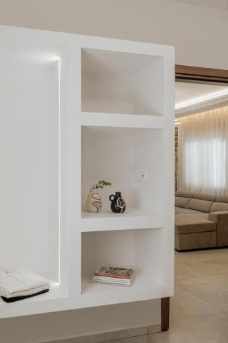 a white wall with shelves in a living room at Almyra Seaside Residence 80meters from the beach in Sísai