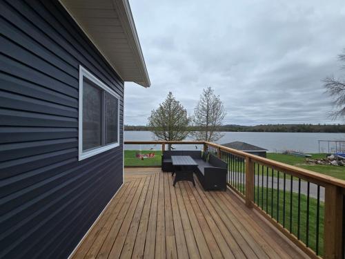 a wooden deck with a bench on the side of a house at Wheel chair Access, Private Boat Launch in Roseneath