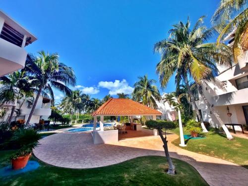 a courtyard with palm trees and a gazebo at Hermosa planta baja con piscina, acceso a la Playa!!! in Cancún