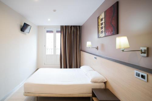 Cama o camas de una habitación en Hostal Las Flores Ramblas