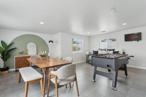 a living room with a table and a piano at NEW Reins & Rivets by PaseoHomesAZ - Heated Pool in Tempe