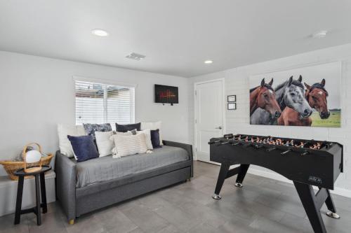 a living room with a couch and a foosball at NEW Reins & Rivets by PaseoHomesAZ - Heated Pool in Tempe