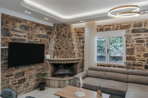 a living room with a stone wall at Almyra Seaside Residence 80meters from the beach in Sísai