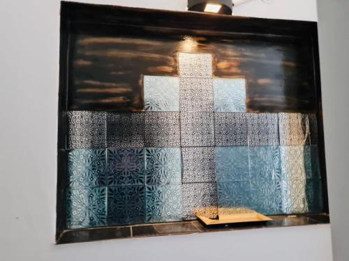 a mosaic tile wall with a cross on it at Altos del Norte - Salta la Linda ! in Salta