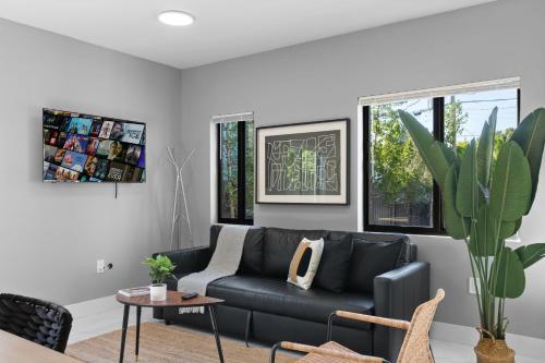 a living room with a black couch and a table at Spacious 4-BR House W Free Parking in Miami