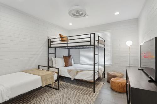 a bedroom with two bunk beds and a desk at NEW Reins & Rivets by PaseoHomesAZ - Heated Pool in Tempe