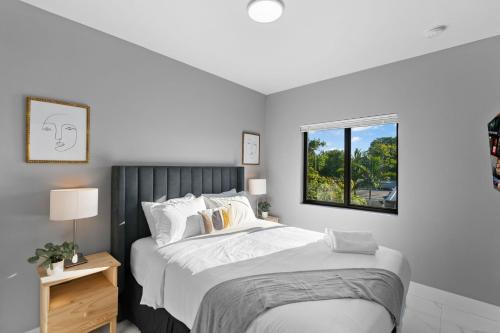 a white bedroom with a large bed and a window at Spacious 4-BR House W Free Parking in Miami