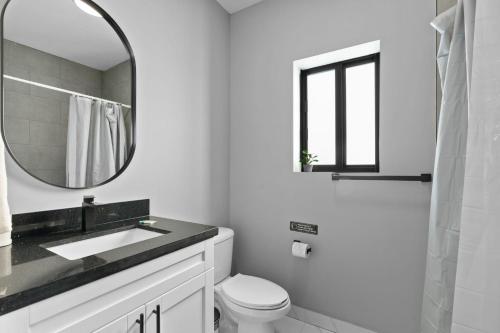 a white bathroom with a sink and a mirror at Spacious 4-BR House W Free Parking in Miami