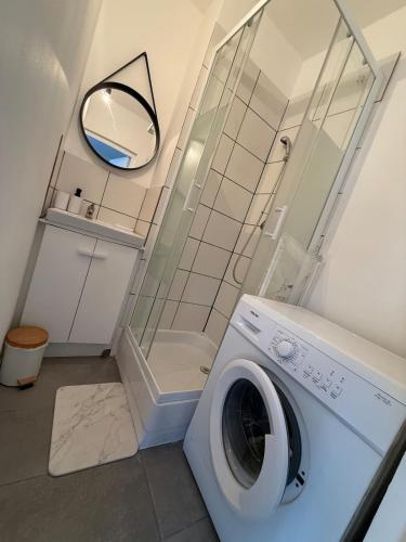 une machine à laver dans une salle de bain avec douche dans l'établissement Maison de ville cosy pour 4 personnes, à Grand-Couronne