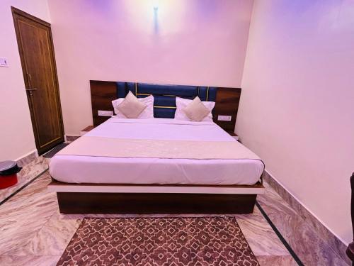 a bedroom with a large bed with white sheets and pillows at Shri Sarju Palace in Orchha