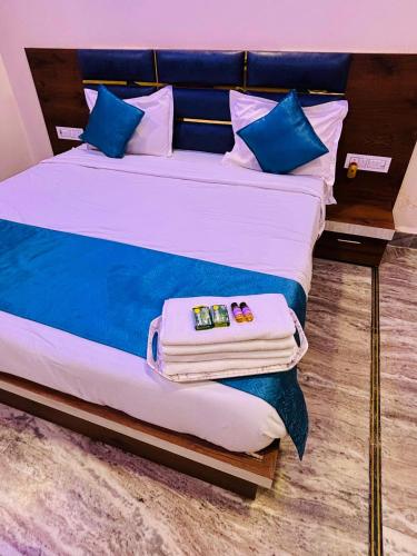 a bed with blue and white sheets and blue pillows at Shri Sarju Palace in Orchha