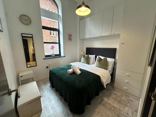 a bedroom with a bed with a teddy bear on it at Modern 2 Bed City Centre Apartment in Leeds